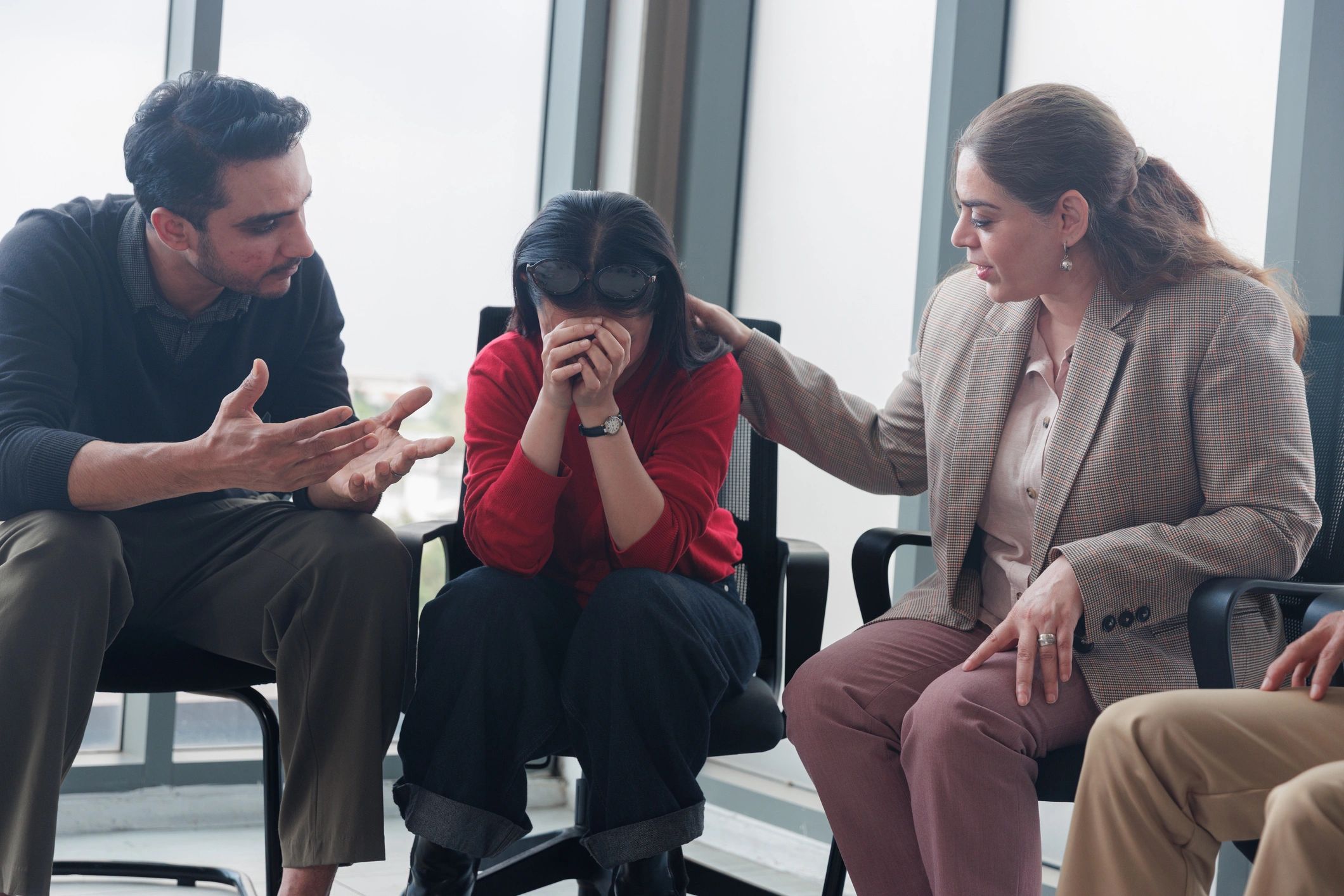 Empathetic Colleagues Comforting Upset Female Coworker in Modern Office